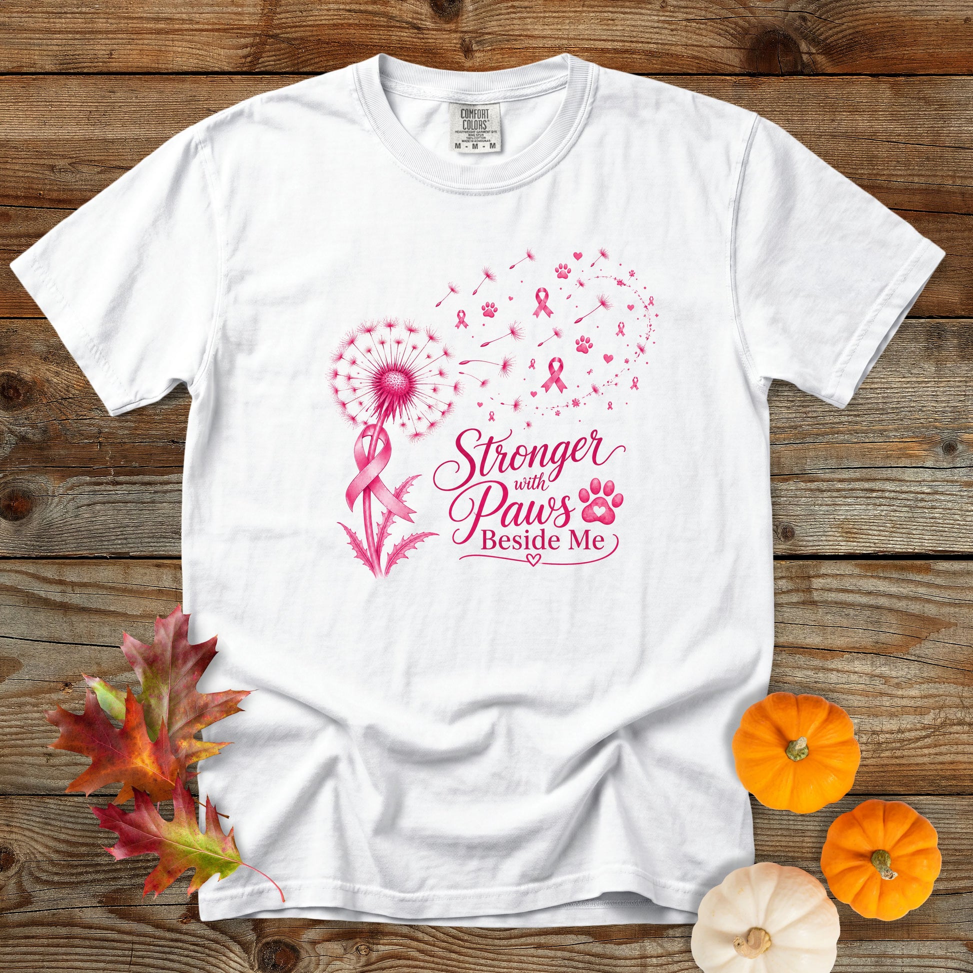 White Comfort Colors dog mom T-shirt featuring a pink breast cancer awareness ribbon, dandelion, paw prints, and the phrase Stronger With Paws Beside Me.